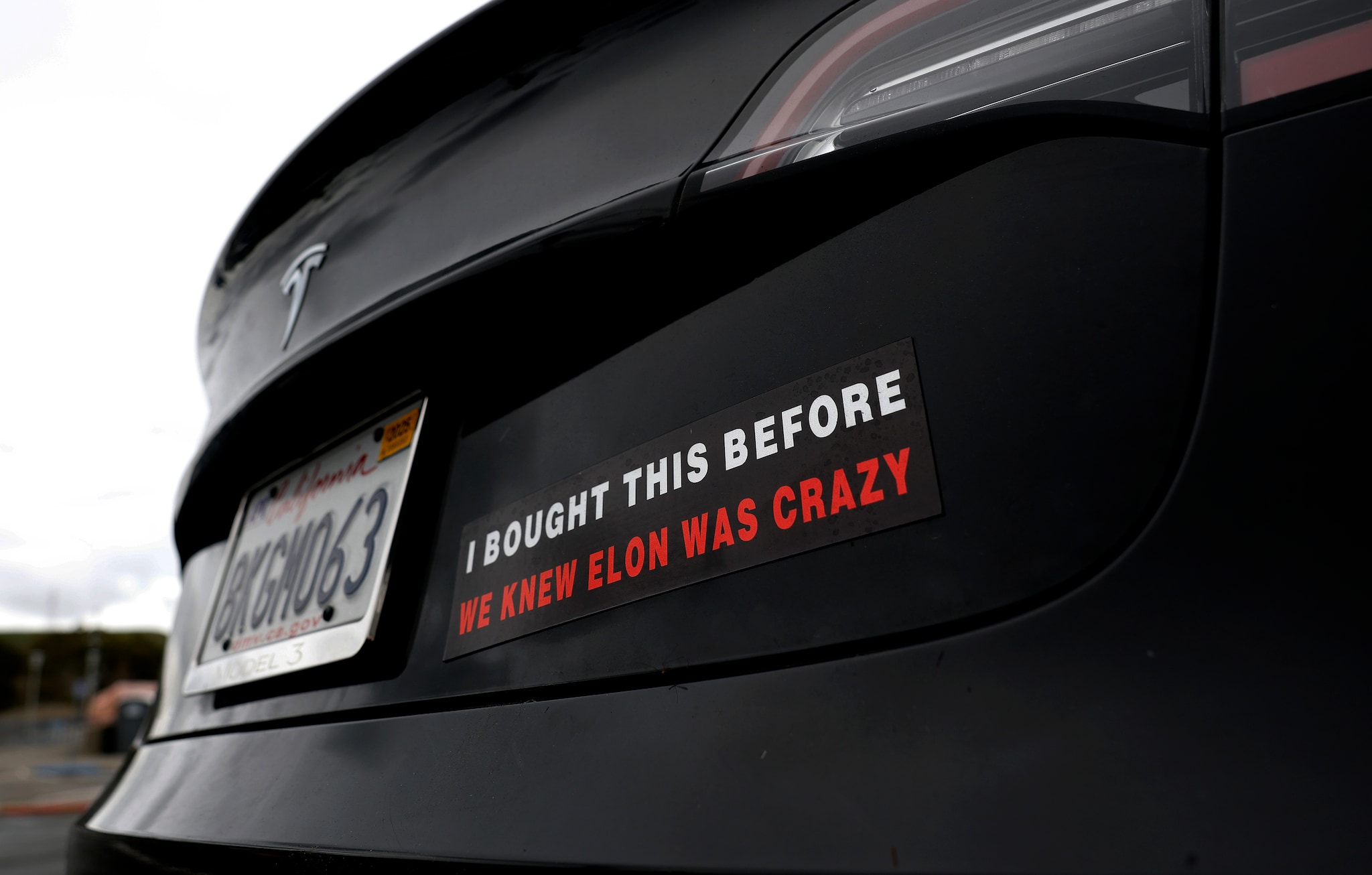 LARKSPUR, CALIFORNIA - MARCH 12: A bumper sticker protesting Tesla CEO Elon Musk is shown on a Tesla Model 3 car on March 12, 2025 in Larkspur, California. Backlash continues to grow against Tesla over Elon Musk and DOGE's handling of government jobs. Elon Musk is the CEO of Tesla. (Photo by Justin Sullivan/Getty Images) Een tekst op een Tesla. Zoals er in de VS veel rondrijden - met díe tekst. Foto: Getty Images.