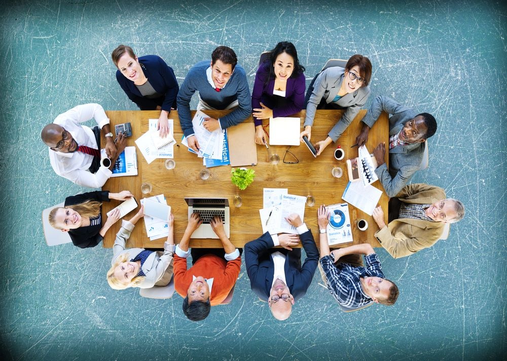 Aan de vergadertafel met het hele team. ‘Managers en leiders moeten regie pakken, ook als het lastig is. Door polarisatie proactief aan te pakken, creëren zij een werkomgeving waarin verschillen bijdragen aan samenwerking en groei, in plaats van een bedreiging te vormen’. Foto: Shutterstock.