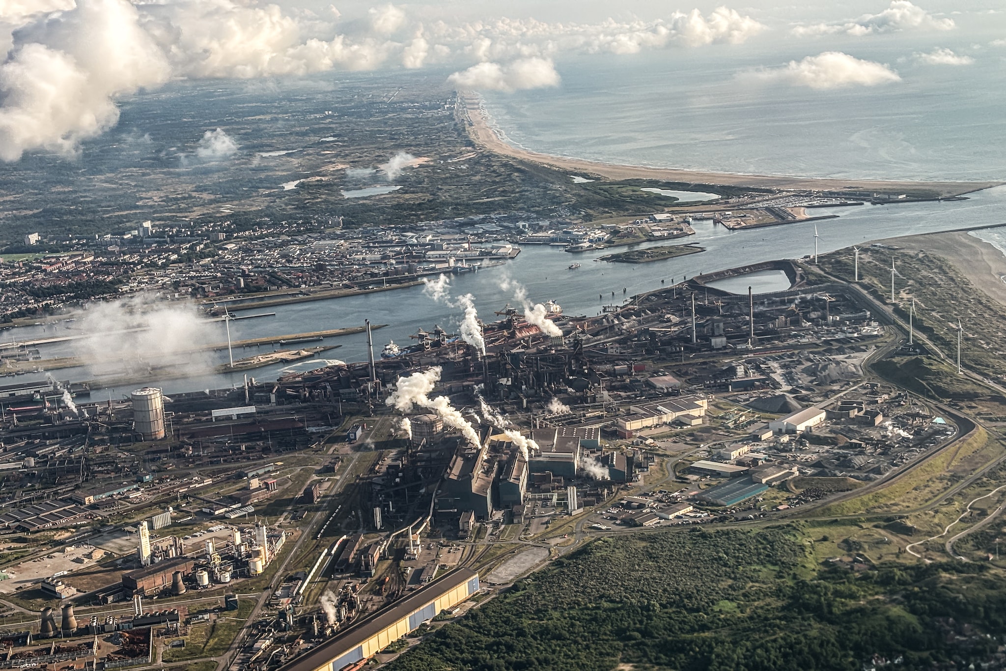 IJmuiden, Nederland, 06-07-2025 | Vanuit het raam van een vliegtuig is Tata Steel in IJmuiden vanuit de lucht gefotografeerd, waarbij het uitgebreide industriële terrein zichtbaar is.
De foto toont de omvang en structuur van de staalindustrie vanuit een unieke luchtpositie. Foto: Joris van Gennip Vanuit het raam van een vliegtuig is Tata Steel in IJmuiden gefotografeerd, waarbij het uitgebreide industriële terrein zichtbaar is. De foto toont de omvang en structuur van de staalindustrie vanuit een unieke luchtpositie. Foto: Joris van Gennip.