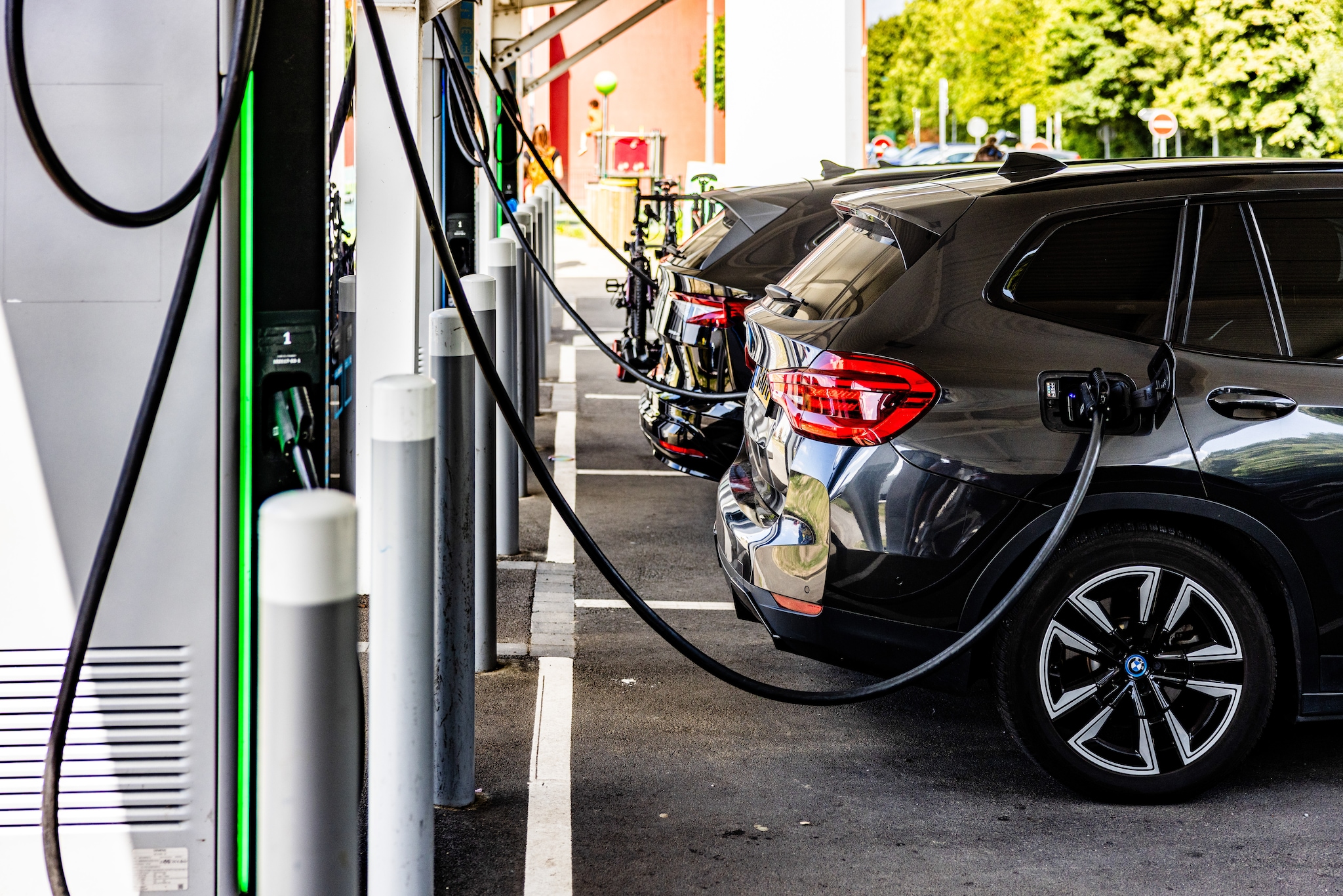 #NLBEELD# JG20250726-002, LILLE - Een elektrische auto bij een snellader langs de snelweg in Frankrijk. Steeds meer Nederlanders gaan met een elektrische auto op vakantie maar het wordt steeds duurder om te laden op het vakantieadres door hoge tarieven.  Noodzakelijke netcapaciteit erbij is ook in Limburg essentieel voor de groeiende vraag naar elektriciteit door onder meer elektrische auto’s. Foto: Jeffrey Groeneweg.