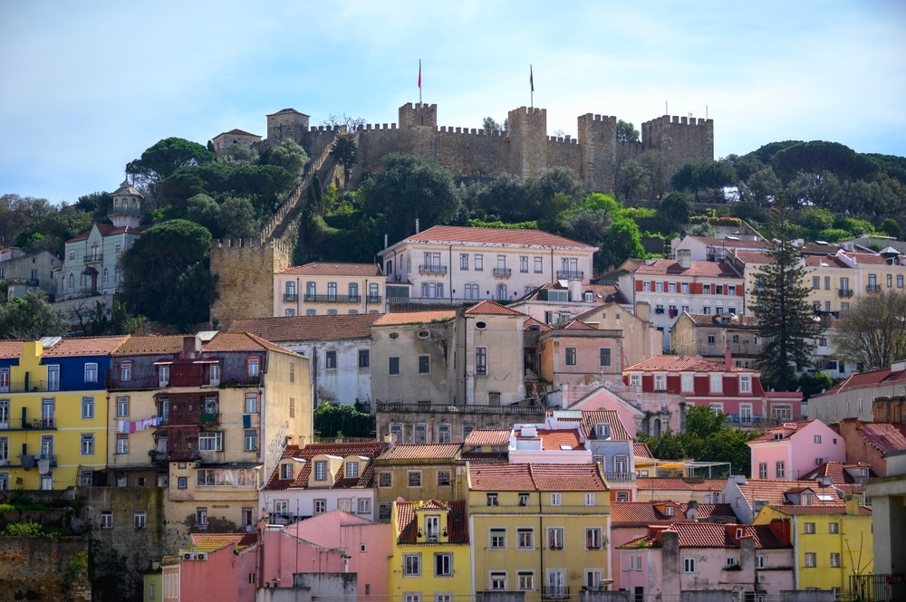 Colorful facades beneath Lissabon castle. Wonen en werken in Lissabon met bijvoorbeeld dit uitzicht... Foto: Shutterstock