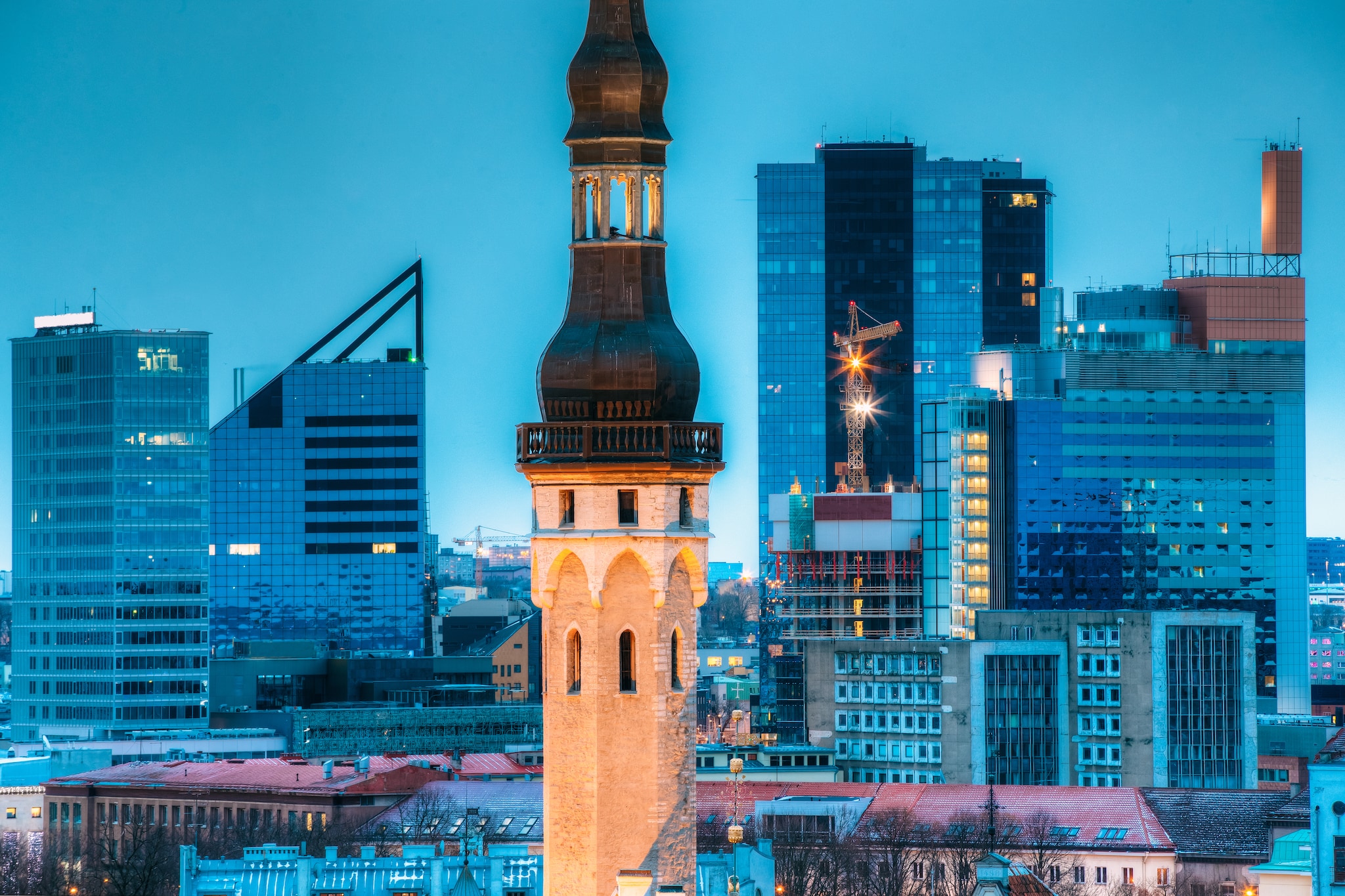 Tallinn, Estonia. Tower Of Town Hall On Background With Modern Urban Skyscrapers. City Centre Architecture. Tallinn, Estland. Ook wel het Silicon Valley van Europa genoemd. Foto: Shutterstock
