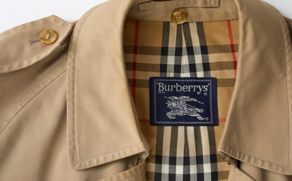 Burberry jas. Burberry’s stap terug naar een klassiek seriflogo en hun ridder-beeldmerk gaf kleur en geschiedenis terug.