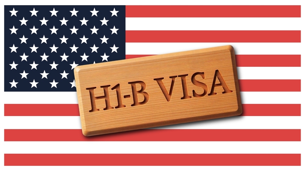H1B Visa Concept on American Flag. Symbolizing U.S. Work Immigration and Employment Opportunities Afbeelding: Shutterstock