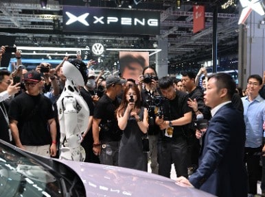 XPeng-CEO verwacht dat hij over tien jaar met robots verkoopt dan auto's. XPeng-CEO He Xiaopeng communiceert met ‘zijn’ robot. Foto: ANP.