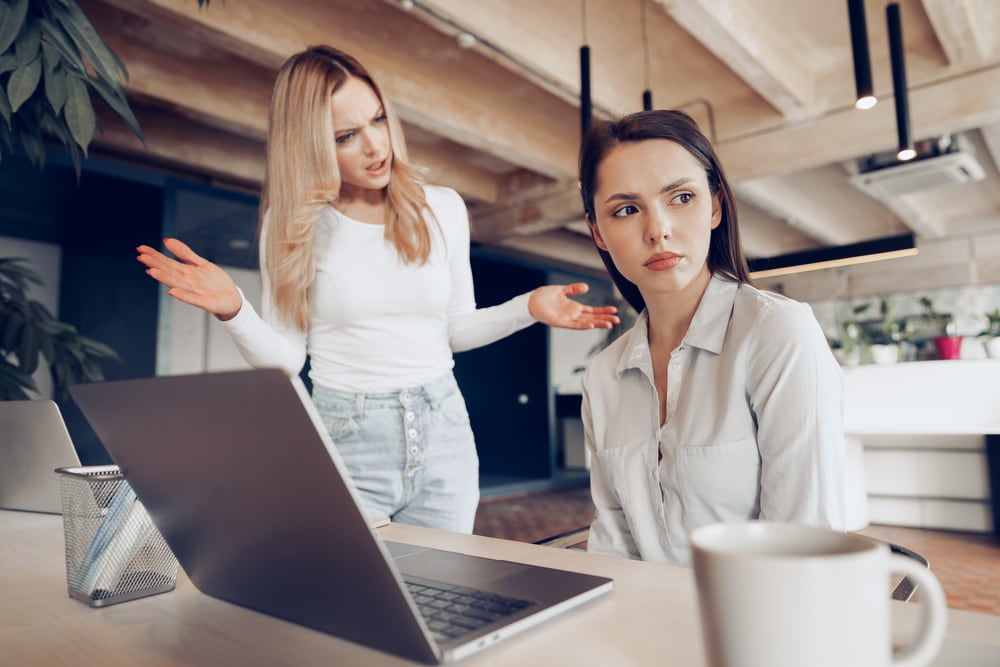 Young female boss scolding her female subordinate for bad work results Shutterstock