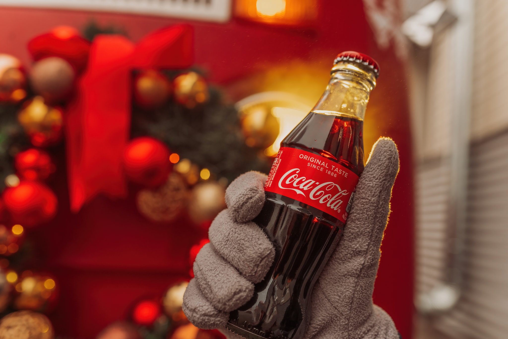MOSCOW, RUSSIA- DECEMBER, 2022: bottle of Coca-Cola in hand at Christmas background Shutterstock