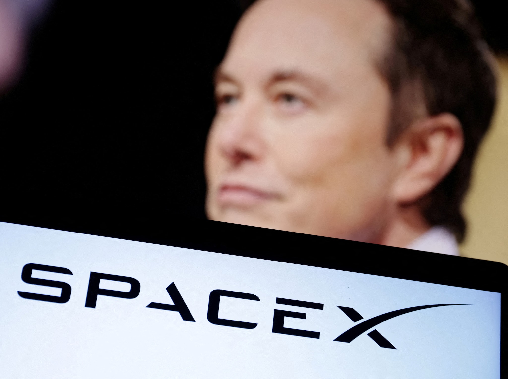 FILE PHOTO: SpaceX logo and Elon Musk photo are seen in this illustration taken, December 19, 2022. REUTERS/Dado Ruvic/Illustration/File Photo Een beursgang voor SpaceX met een beurswaarde van 1 biljoen dollar - zou het? Afbeelding: Reuters.