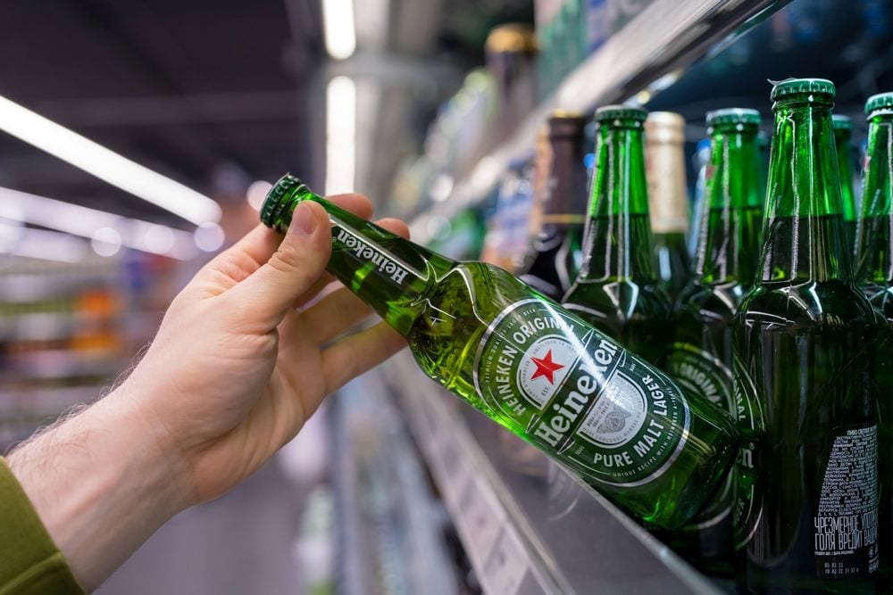 Heineken-bier in de supermarkt. In fles. In 2024 verkocht Heineken wereldwijd een totaal volume van 240,7 miljoen hectoliter bier. Om dit te vertalen naar het aantal flesjes, maken we de rekensom op basis van de standaardmaat van 33 cl (0,33 liter): dan zijn het ongeveer 73 miljard flesjes bier per jaar. Foto: Shutterstock.