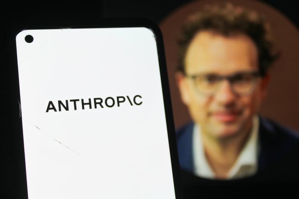 Anthropic-CEO Dario Amodei achter het logo van zijn bedrijf.