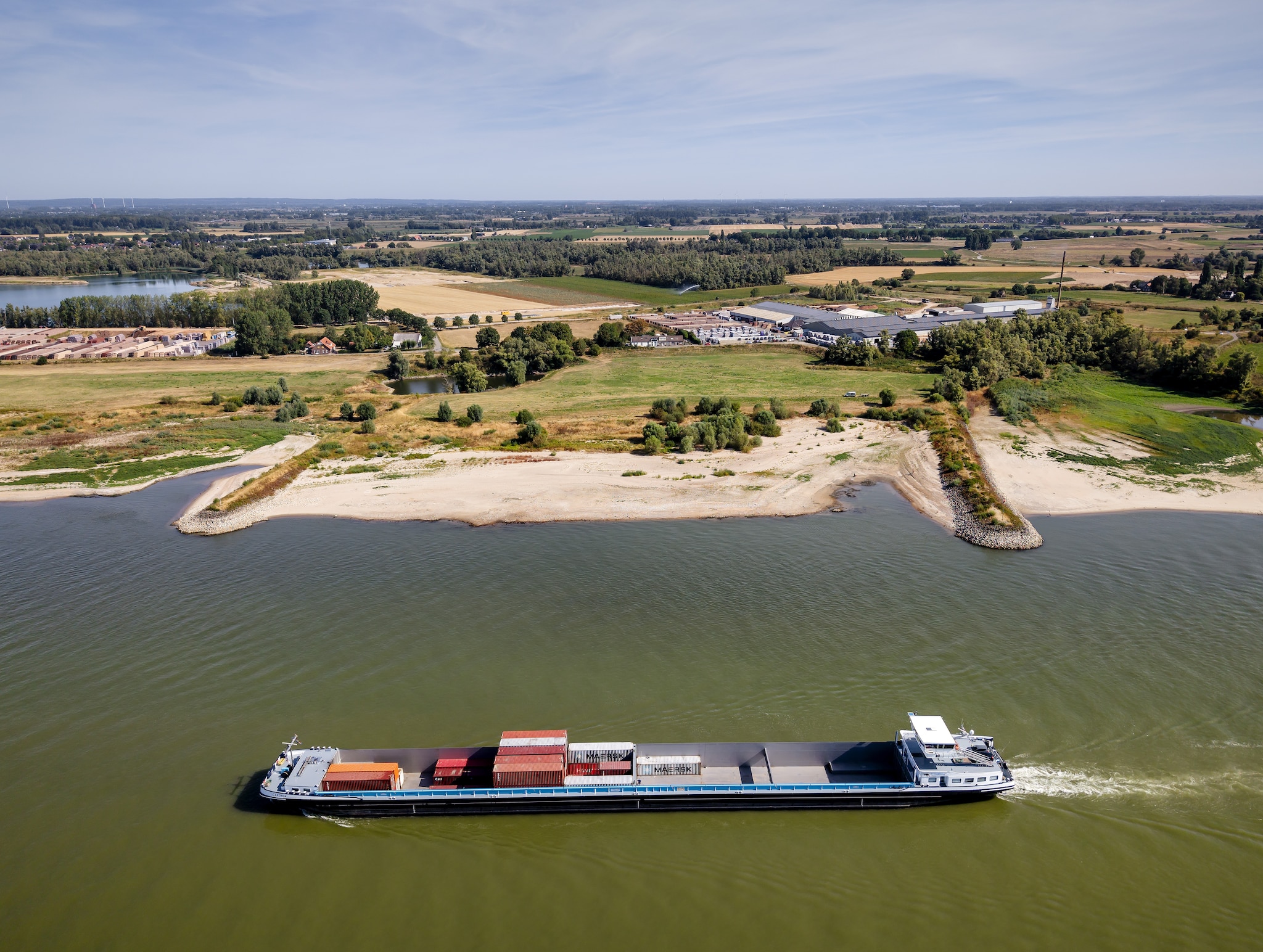 Dronefoto van een binnenvaartschip over de Rijn. De afvoer van de Rijn is lager dan ooit gemeten.
