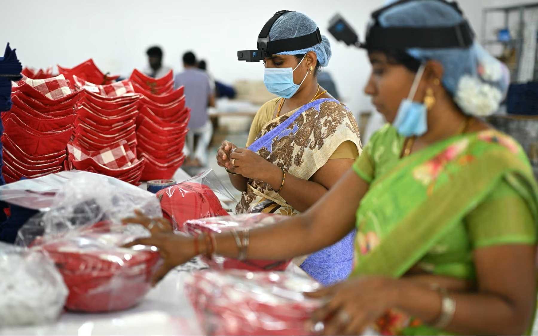 Onder meer bij Pearl Global Industries in India werkt personeel met AI-headsets om data te verzamelen. Reuters